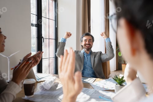 Preview: Celebrating engineer receiving congratulations from colleagues for successful project