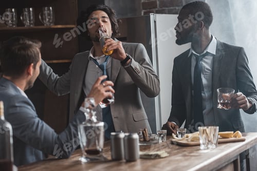 Preview: young multiethnic businesmen drinking alcohol beverages together