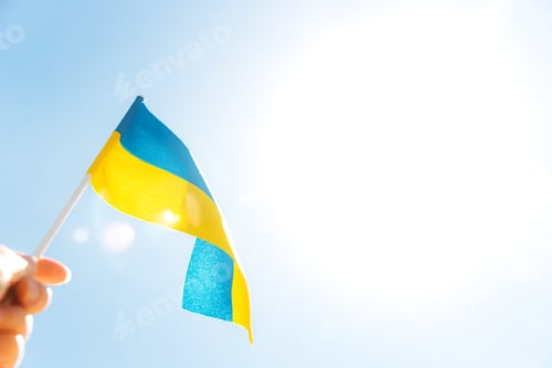 Preview: Hand holding large bicolor yellow blue Ukrainian state flag