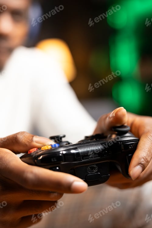 Preview: Close up shot of gamepad used by man enjoying gaming session