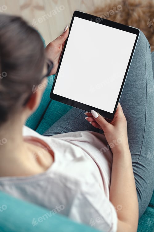 Preview: Young woman using digital tablet while sitting in a comfortable