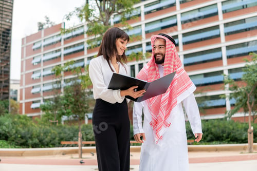 Preview: Female manager showing papers to Arab client