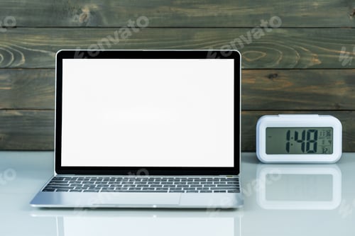 Preview: Laptop mockup and alarm clock with wood background on the work table