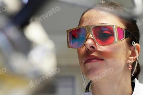 Preview: Close up of female scientist wearing red protective glasses