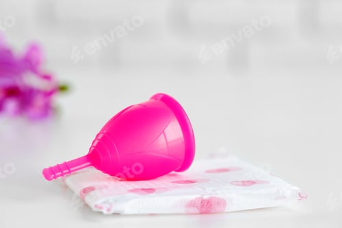 Preview: Menstrual cup and hygienic pad on table close up