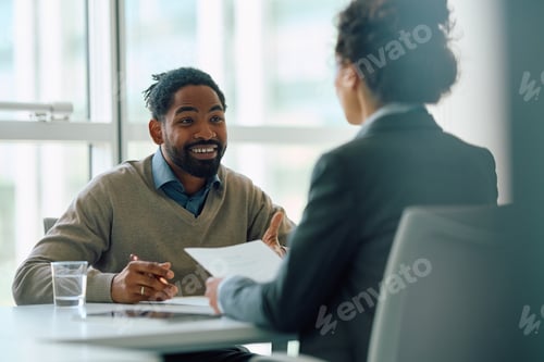Preview: Happy black man having a meeting with insurance agent in the office.