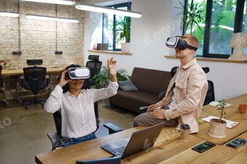 Preview: Inspired man and woman coworker wearing vr goggles in office
