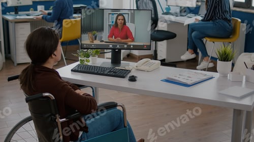 Preview: Immobilized entrepreneur talking with coworker during video conference