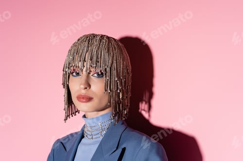 Preview: Fashionable woman in jewelry headwear looking at camera on pink background with shadow