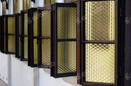 Preview: Set of open wooden windows with yellow glass on the building