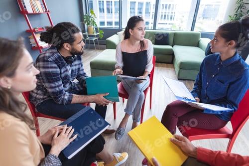 Preview: Diverse group of creative colleagues talking at casual meeting