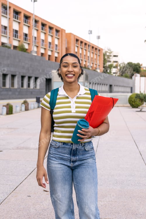 Preview: Happy young student walking on university campus