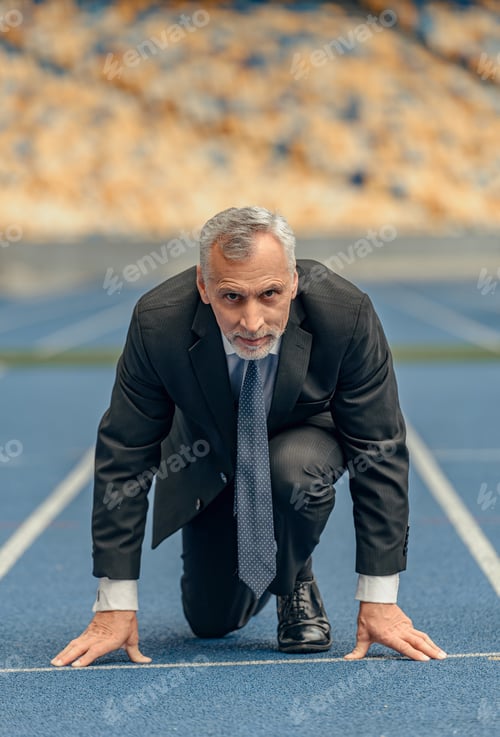 Preview: Front view photo of mature businessman standing on race track