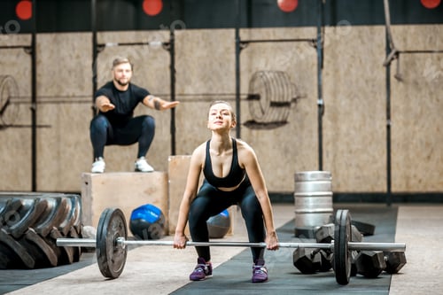 Preview: Woman lifting up a burbell in the gym