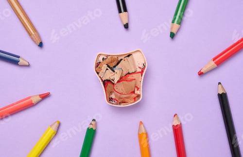 Preview: Multicolored wooden pencils and sharpener on purple background, top view