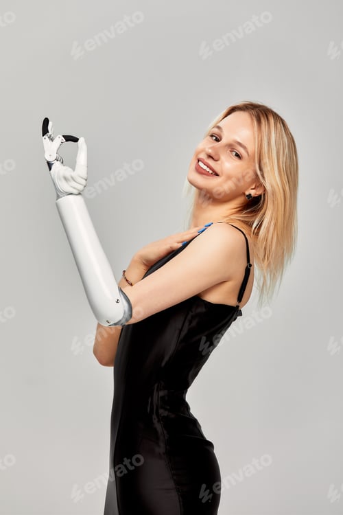 Preview: Studio portrait of beautiful young blonde girl with disability wearing sensory bionic prosthetic arm