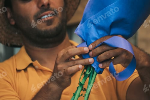 Preview: Closeup of a man who’s making a bouquet of flowers