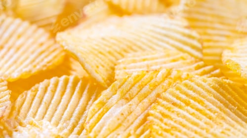 Preview: Yellow Crispy Ridged Potato Chips Close Up. Food Background