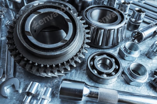 Preview: Close-up view of assorted metal tools and mechanical parts on a workbench during the daylight hours