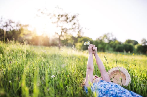 Preview: A small girl lying on the grass in spring nature. Copy space.