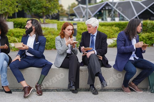 Preview: Multi generational business people eating together healthy lunch outside of office