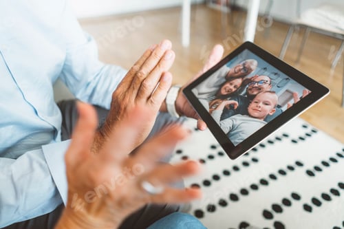 Preview: Over the shoulder view of senior couple talking to family over video call