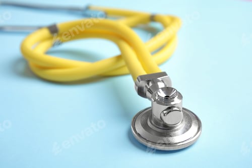 Preview: Stethoscope with space for text on color background, closeup. Medical tool