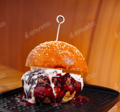 Preview: Gourmet burger with creamy sauce on black plate