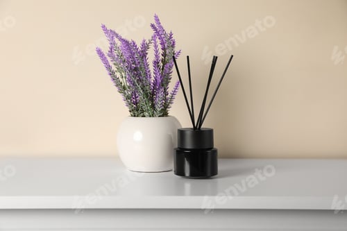Preview: Aromatic reed air freshener and lavender flowers on white table indoors
