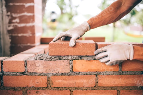 Preview: professional construction worker laying bricks and building barbecue in industrial site