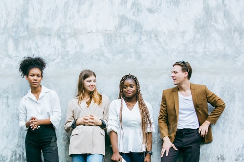 Preview: creative marketing team of young diverse professionals standing together outdoors