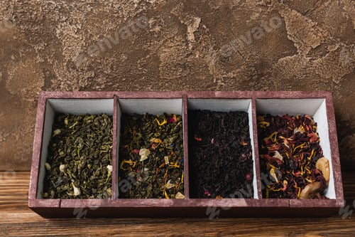 Preview: Top view of dry tea in box on wooden surface on textured stone background
