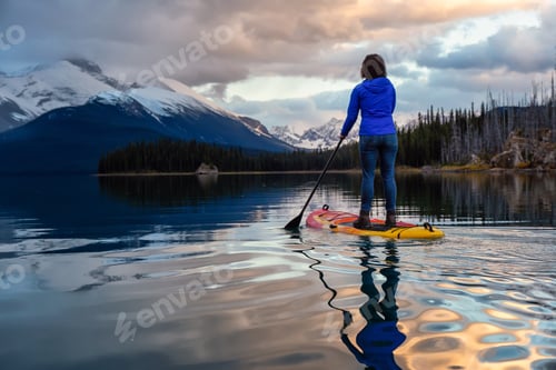 Preview: Girl Paddle Boarding in a peaceful and calm glacier lake
