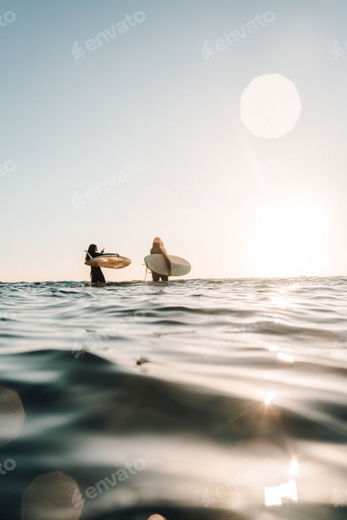 Preview: Women surfers with longboards in the sea on a beautiful sunny day in Algarve, Portugal