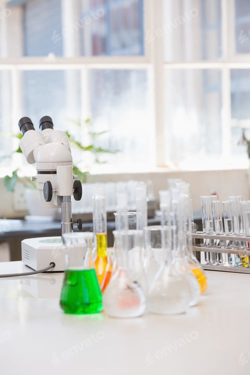 Preview: Beakers with chemical fluid and microscope in laboratory