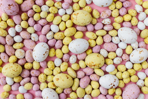 Preview: Colorful chocolate eggs easter background on pink. Candy banner. Happy Easter