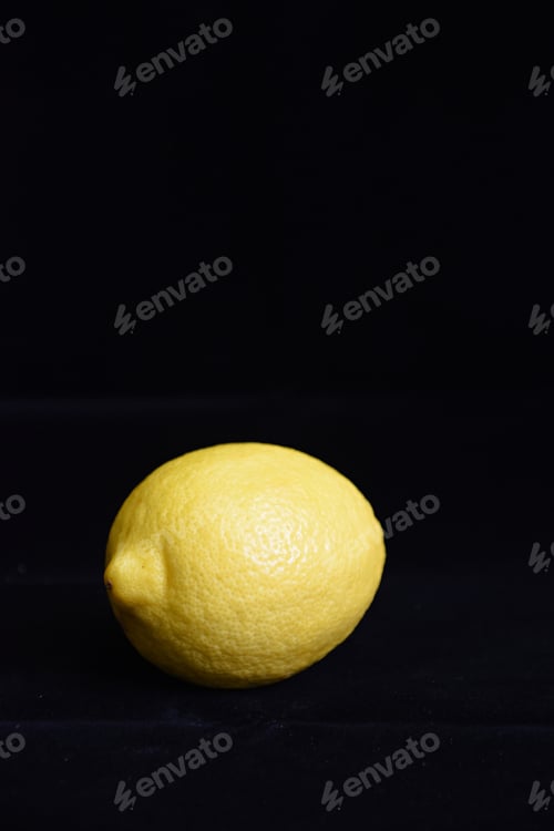 Preview: a single yellow lemon on black velvet background
