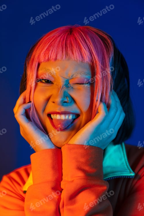 Preview: Asian girl with pink hair winking and showing her tongue