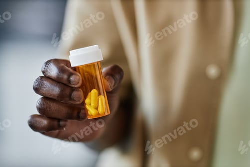 Preview: Closeup of Black Man Holding Plastic Bottle With Pills