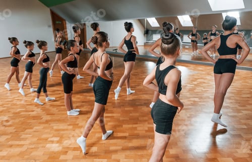 Preview: Group of female kids practicing athletic exercises together indoors