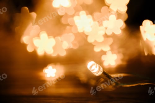 Preview: close up view of festive garland and stars bokeh lights backdrop