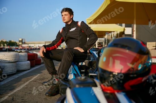 Preview: An aspiring racer poses confidently next to a gokart