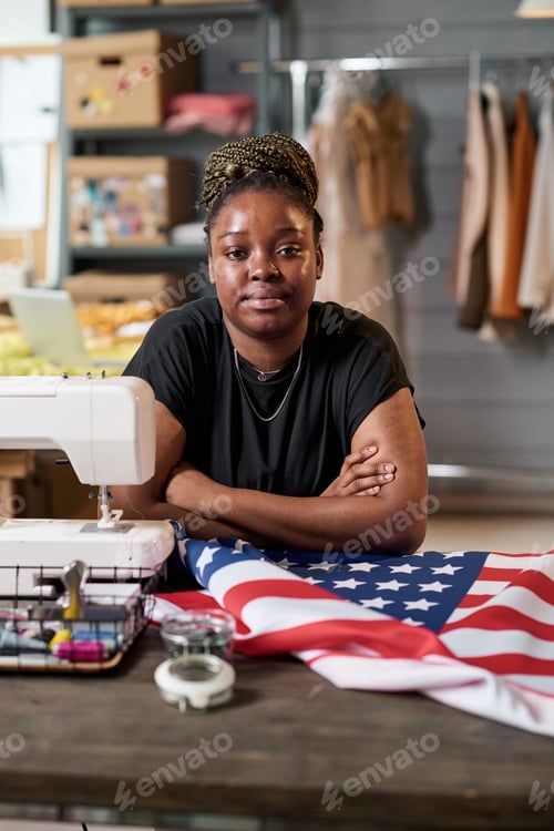 Preview: Young African American female tailor looking at camera by her workplace