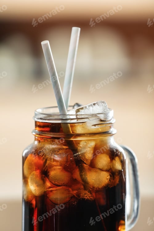 Preview: Mason jar of cola with ice against blurred background