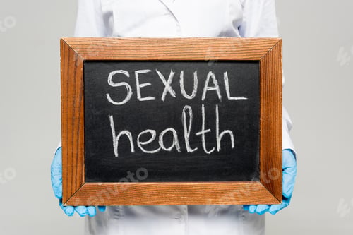 Preview: cropped view of doctor in white coat and latex gloves holding chalkboard with sexual health