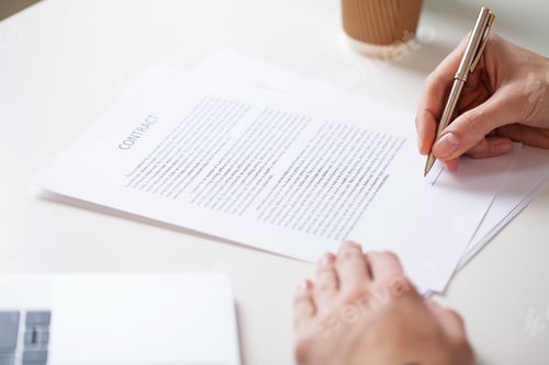 Preview: Man signs a contract at a desk in a company office