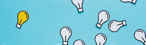 Preview: panoramic shot of paper light bulbs scattered on blue background, business concept