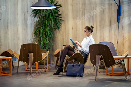 Preview: Elegant young businesswoman working with her digital tablet sitt