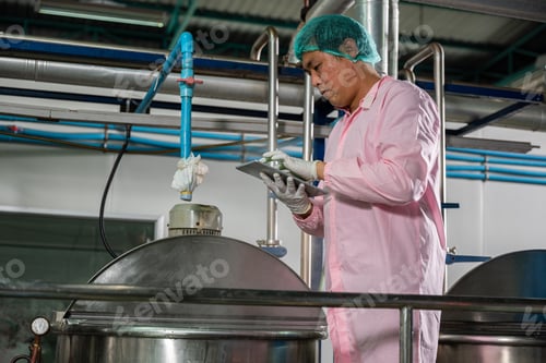 Preview: Worker using tablet in beverage factory oversees soda water filling