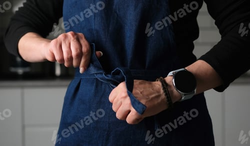 Preview: Woman Tying A Chief Apron In The Kitchen